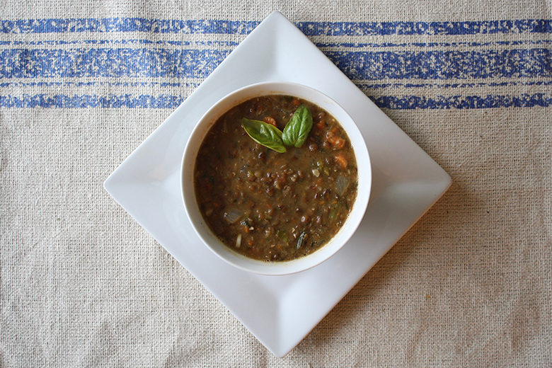 Lentil soup in a white bowl on a kitchen towel background