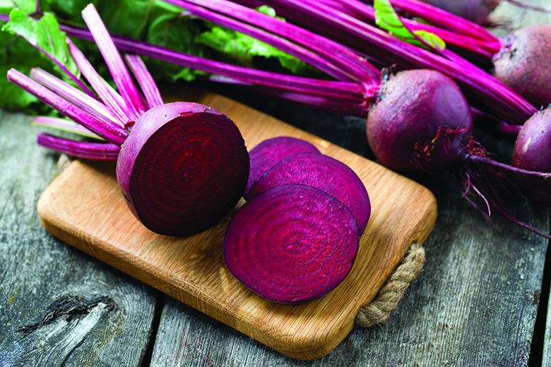 fresh sliced beetroot on wooden surface