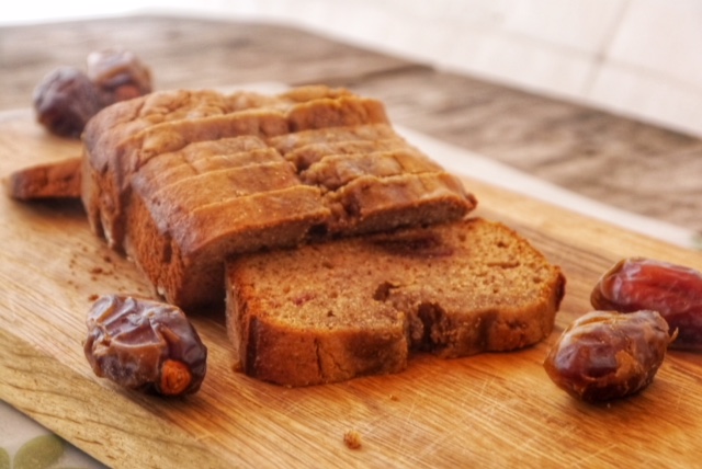 Carob Date Bread on a cutting board with fresh dates