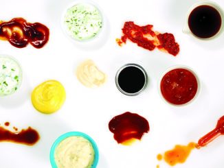 Different condiments on white background