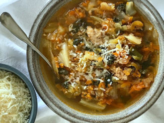 Easy Sausage, Cabbage, Kale and Carrot Soup in a bowl with grated parmesan cheese for garnish