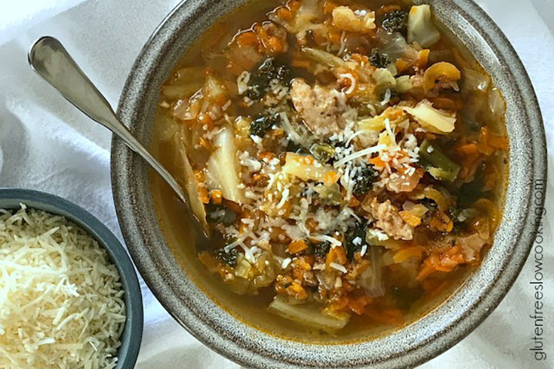 Easy Sausage, Cabbage, Kale and Carrot Soup in a bowl with grated parmesan cheese for garnish