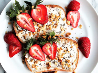 Toast with cream cheese, granola, seeds and cut strawberries