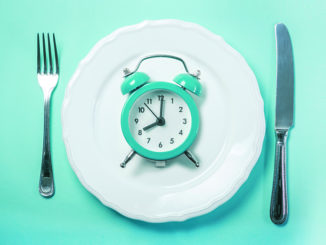 Intermittent fastin concept - empty plate on blue background, copy space