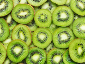 Heap of sliced ripe kiwi as textured background