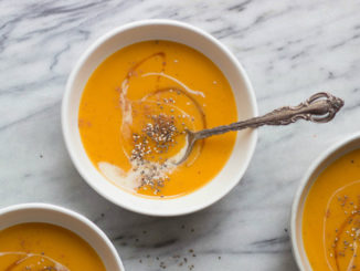 Maple Sweet Potato and Apple Soup in white bowl on marble background