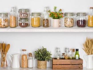 Modern kitchen shelves with various food ingredients on white background
