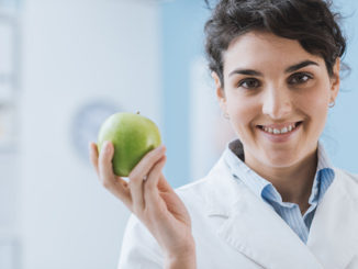 Professional nutritionist holding a fresh apple