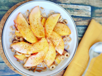 Peaches and Cream Protein-Packed Cereal Bowl with a cereal and spoon and a wooden background