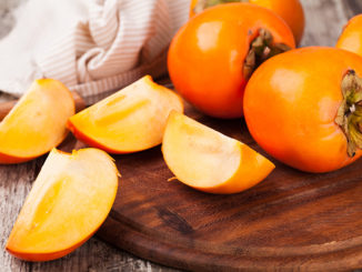persimmons on wooden background