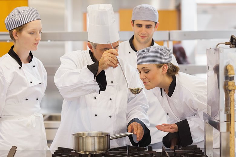 Student tasting the teachers soup in culinary school
