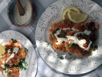 Spicy Shrimp Cakes with Creamy Yogurt Dressing served on two plates dappled with sunshine