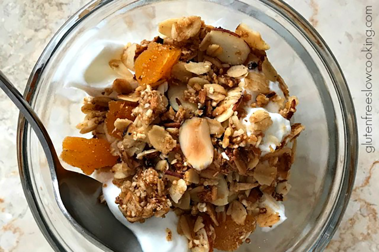 Springtime Slow Cooker Granola, with yogurt, in a bowl with spoon