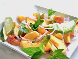 Summer Peach & Avocado Salad with Red Onion and Lime on a square white plate on a white background