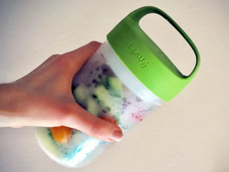 hand holding Lekue Jar To Go filled with veggies