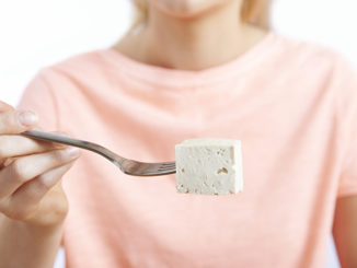 Close Up Of Woman With Tofu On Fork