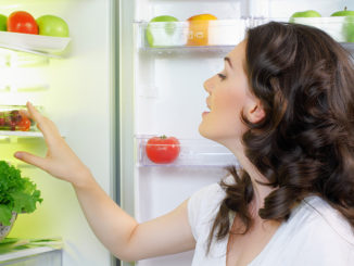A hungry girl opens the fridge