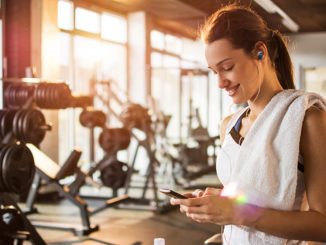 Woman dialing cellphone at gym
